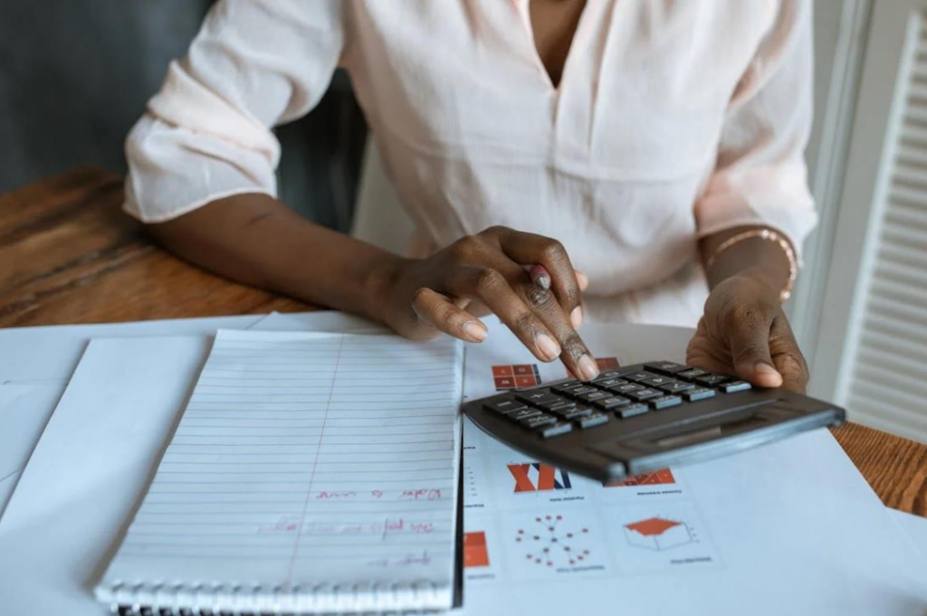 A close-up of a woman working out a sum on a calculator